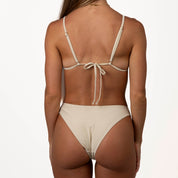 Rear view of a person with long hair wearing the Honey Swim Champagne Shimmer Triangle | Top, featuring adjustable straps and a tied back closure, set against a plain white background.