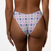 Modeling Honey Swims Capri Classic Bottoms against a white background, the geometric and floral design stands out in a flattering scoop shape, offering moderate coverage.