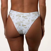 Person wearing Honey Swims Serenity Underwire Set high-waisted white bikini bottoms with a beige house, bicycle, and tree pattern. These European-style bottoms offer enhanced support.