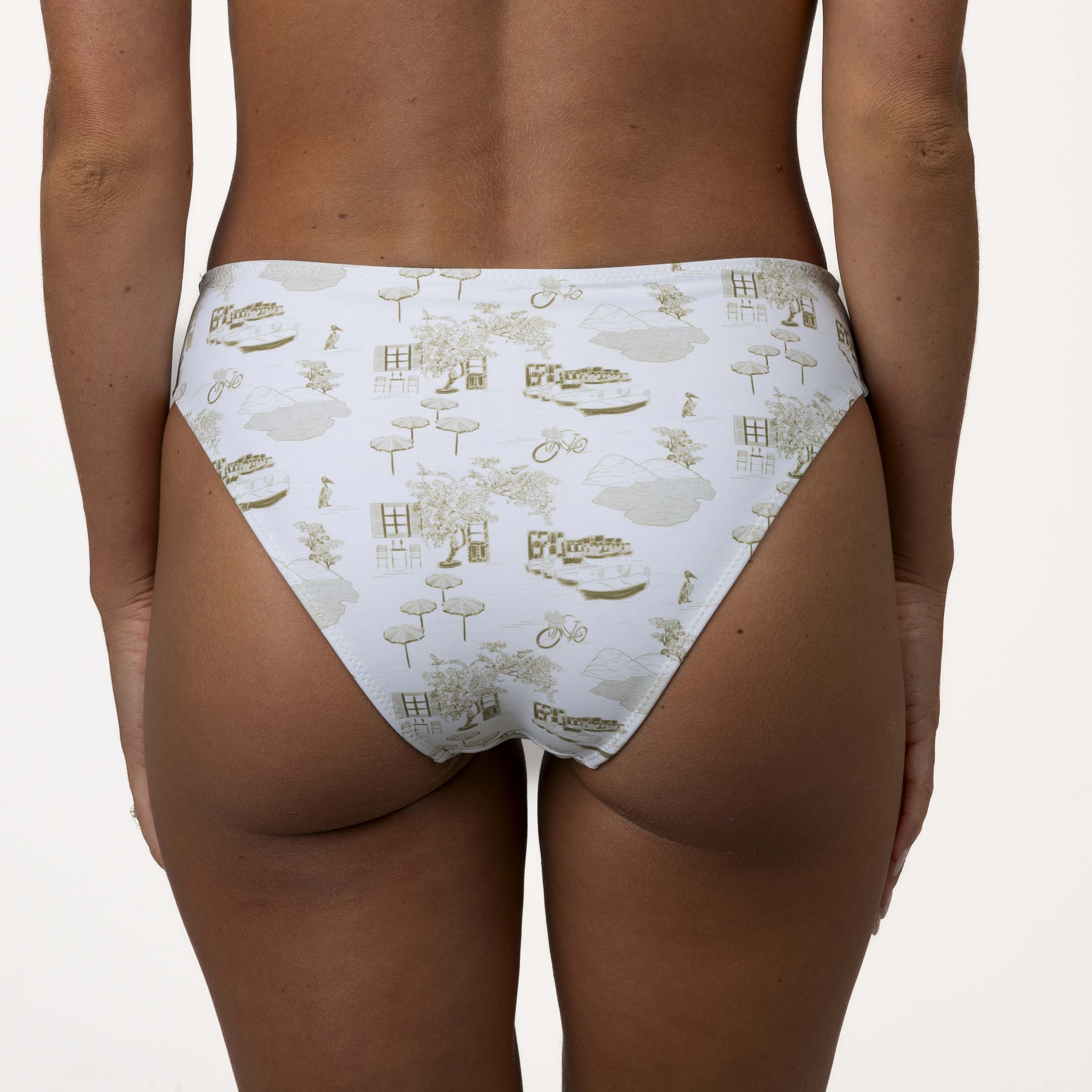 A person models Honey Swims Serenity full coverage bottoms, featuring a smooth texture and printed design of buildings, trees, and bicycles, shown from the back against a plain background.