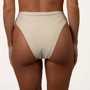 Rear view of a person wearing the Honey Swim Champagne Shimmer Bandeau Set, showcasing high-waisted, light-colored bikini bottoms with a strapless tie-back design against a plain background.