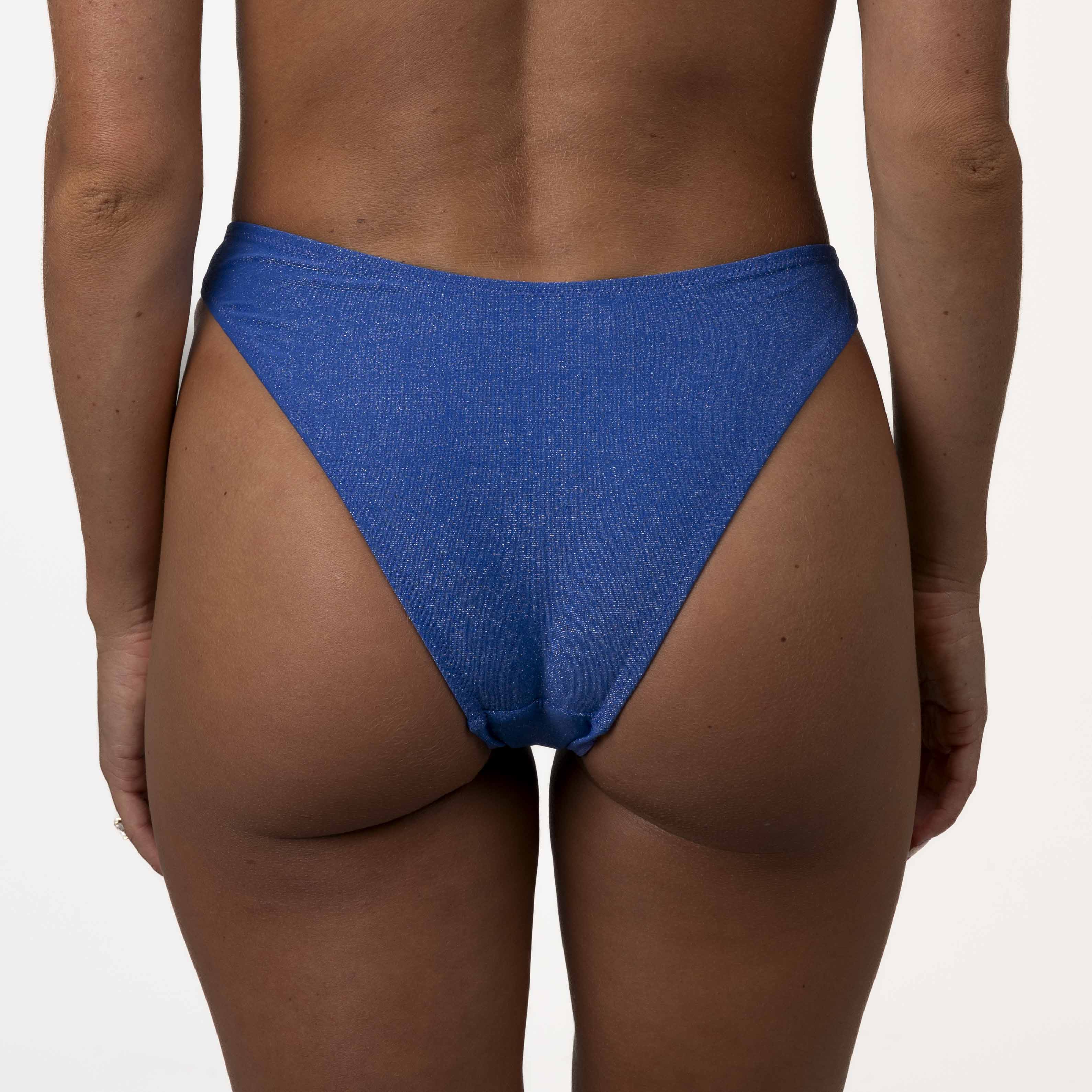 A model showcases Honey Swims Azure Shimmer Bralette Set, highlighted by its striking design and subtle elegance, against a plain white background.