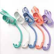 Five Honey Snorkel Kits from Honey Swim in mint green, white, blue, coral, and lavender are lined up with matching snorkels. Their design provides a panoramic view against the clean white backdrop.