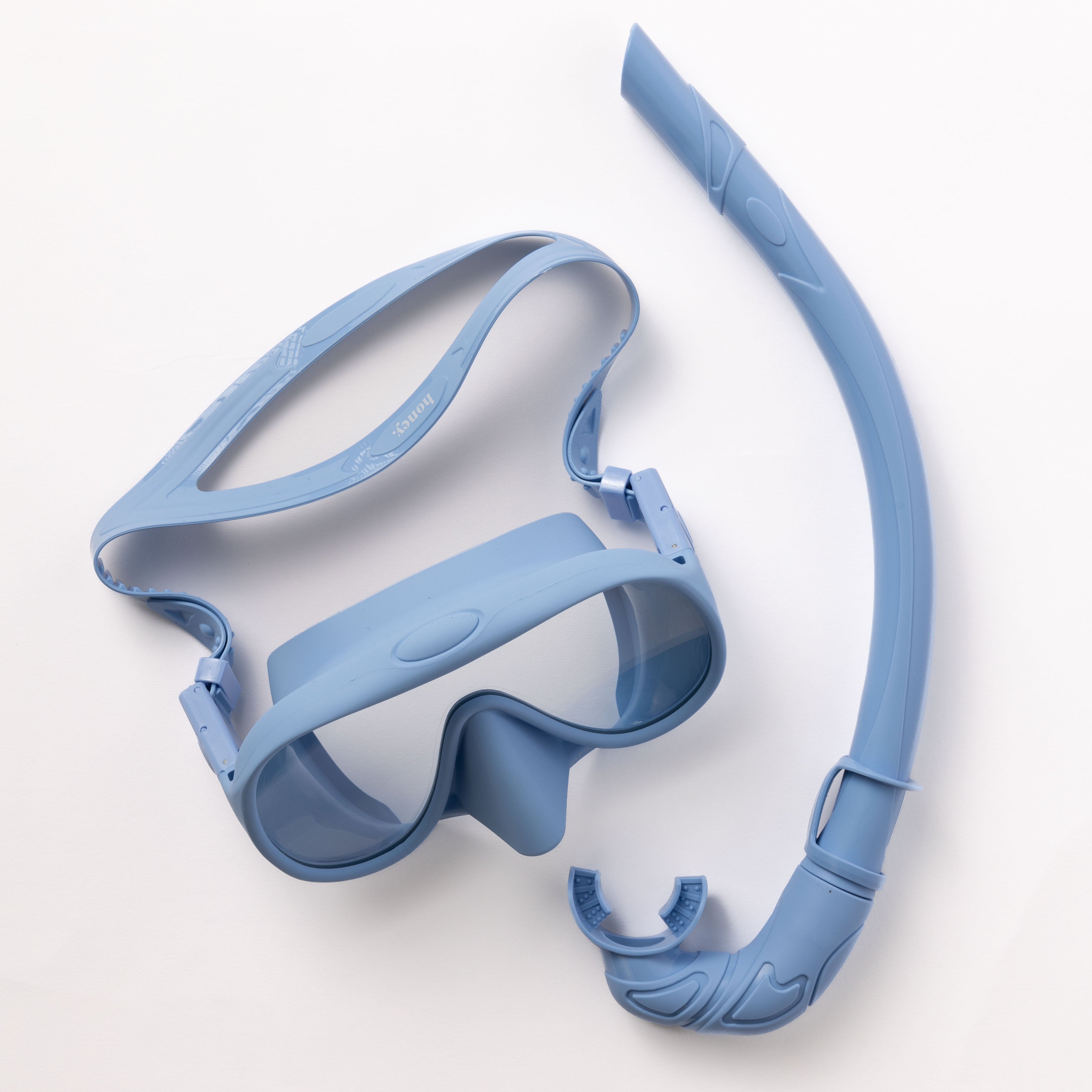 The Honey Swim Sky Blue Snorkel Set features a sky blue mask with tempered glass lenses for a clear panoramic view and an adjustable strap, and a curved snorkel with a mouthpiece, all set against a white background.