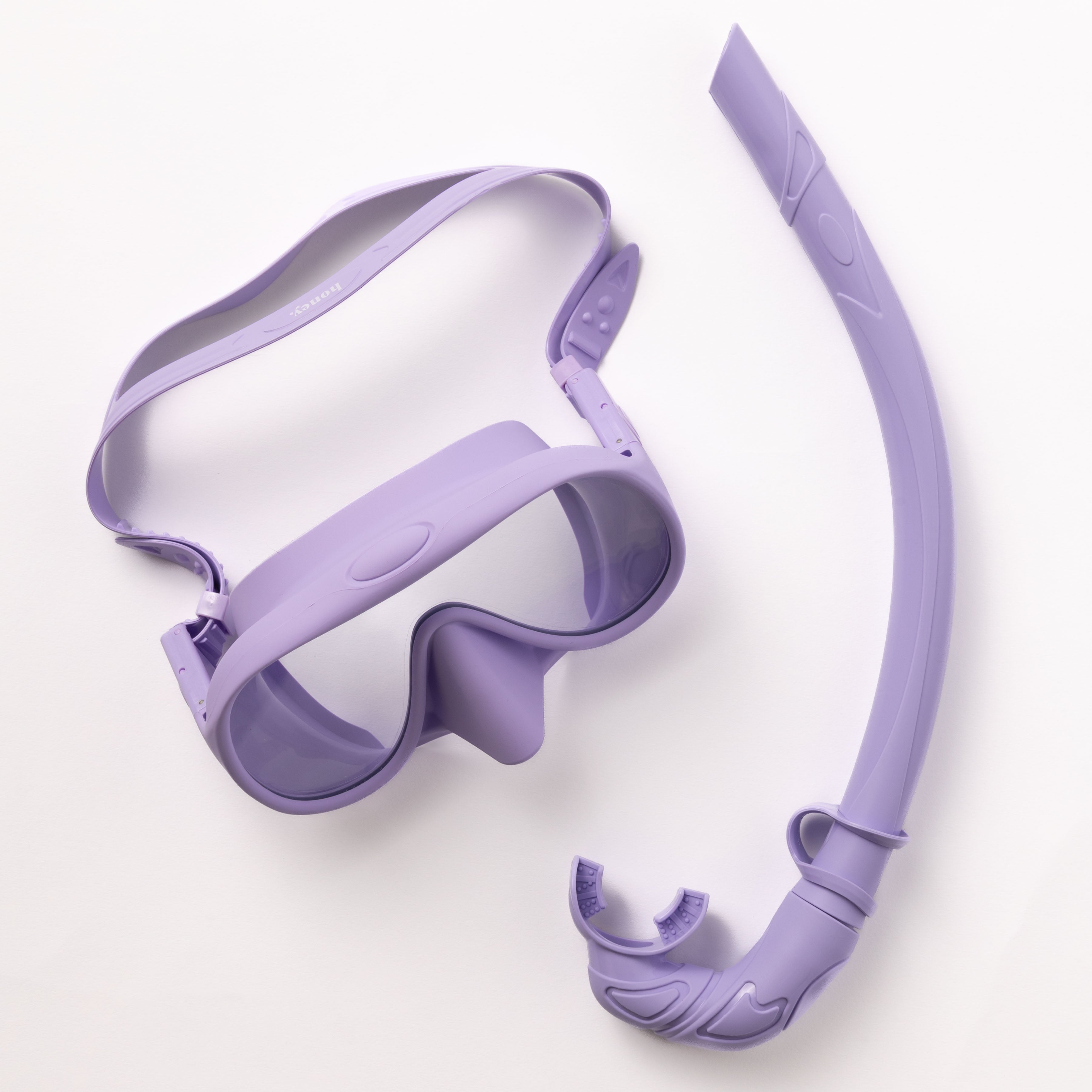 The Honey Swim Purple Snorkel Set includes lavender-colored goggles with clear lenses and an adjustable strap, plus a panoramic view snorkel with a mouthpiece and flexible corrugated section, displayed on a white background.