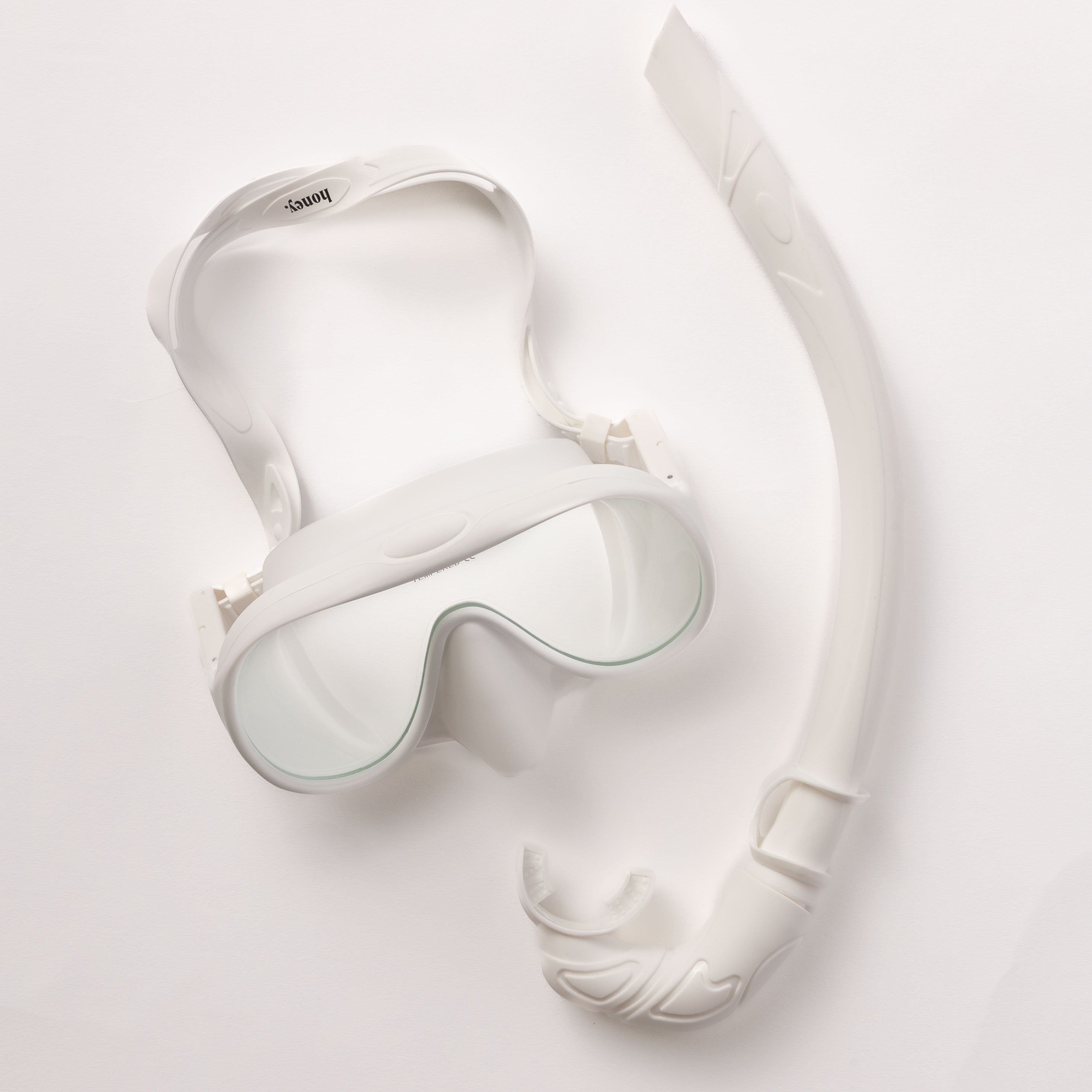 The Honey Swim White Snorkel Set is shown on a plain backdrop, featuring clear lenses for a panoramic view and a snorkel with a curved design and comfortable mouthpiece.