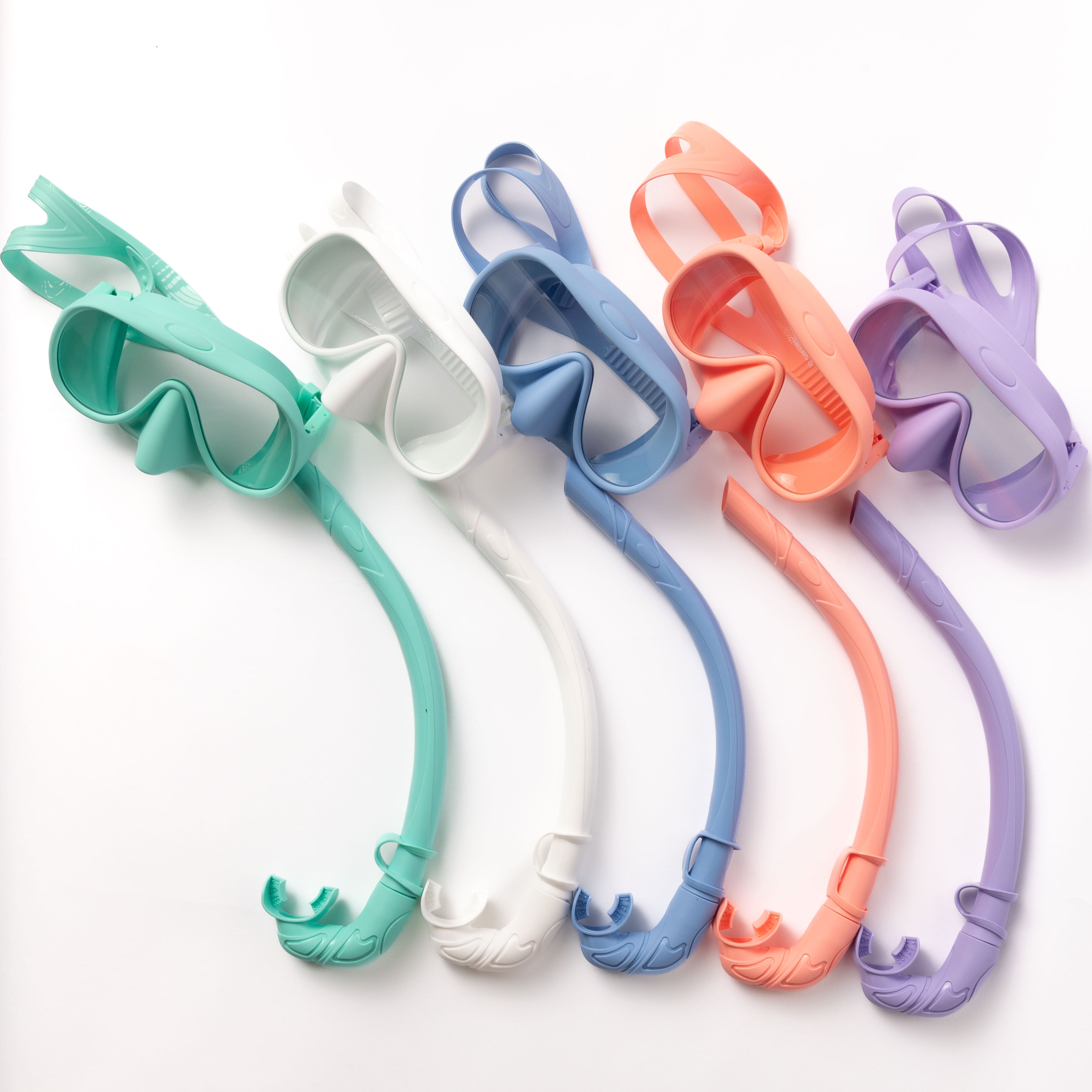 Five Honey Snorkel Kits from Honey Swim in mint green, white, blue, coral, and lavender are lined up with matching snorkels. Their design provides a panoramic view against the clean white backdrop.
