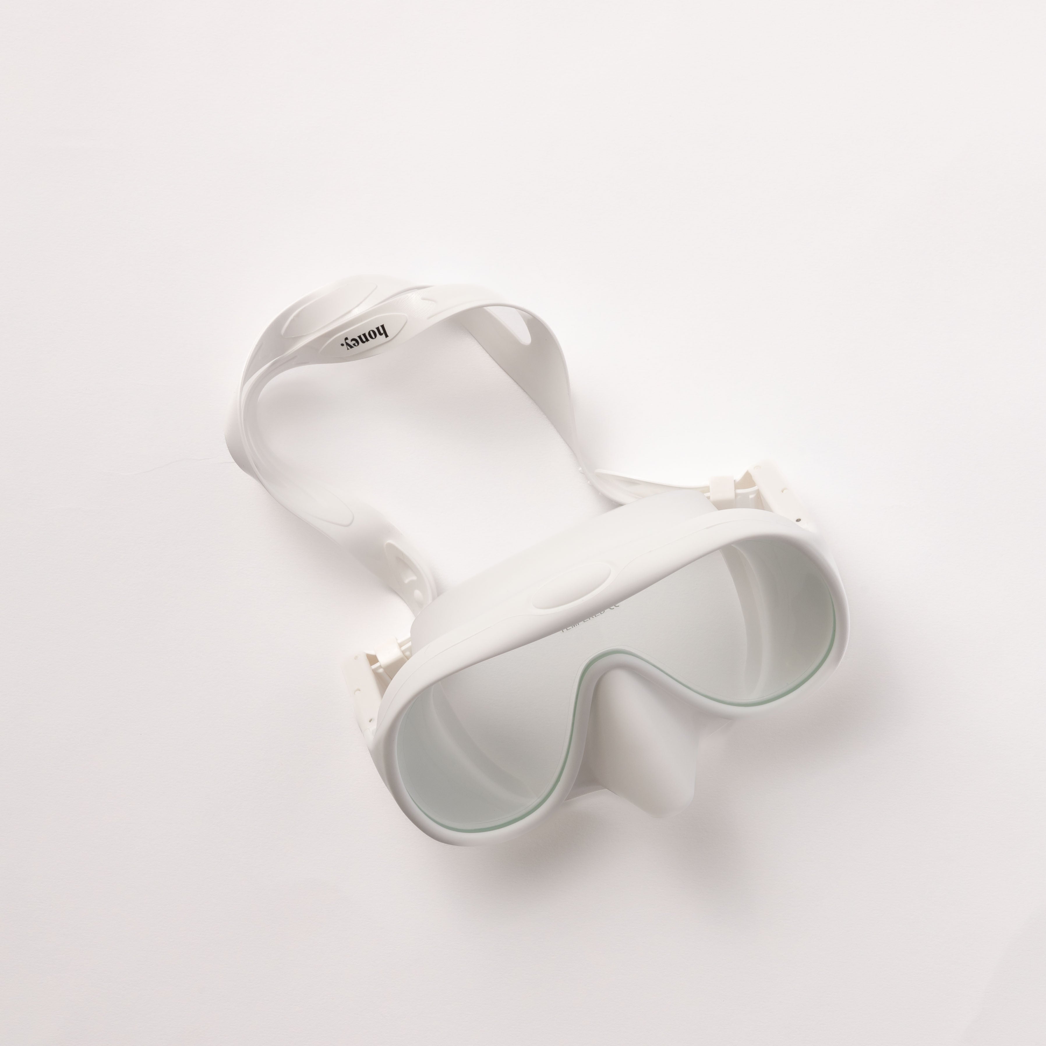The Honey Swim Honey Goggles have a sleek white design and adjustable strap, providing a leak-proof fit for panoramic snorkeling adventures.