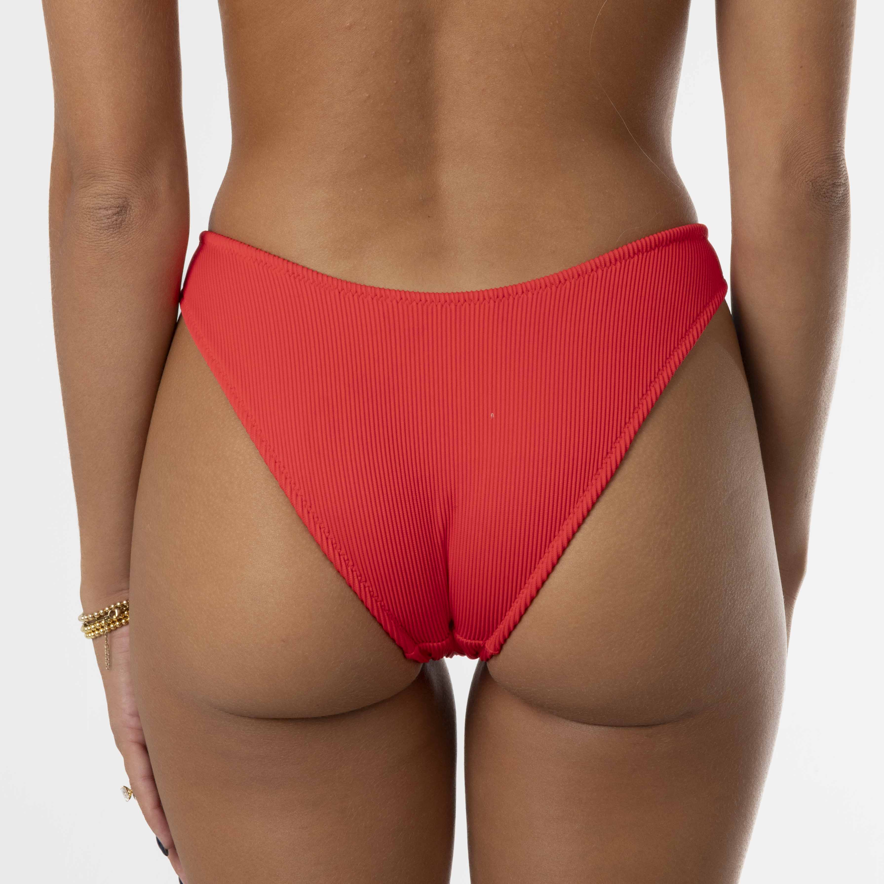 A person embodies comfort and style, wearing the Cherry Ribbed Bralette Set by Honey Swim against a white background, with elegance added by a gold bracelet on their right wrist.